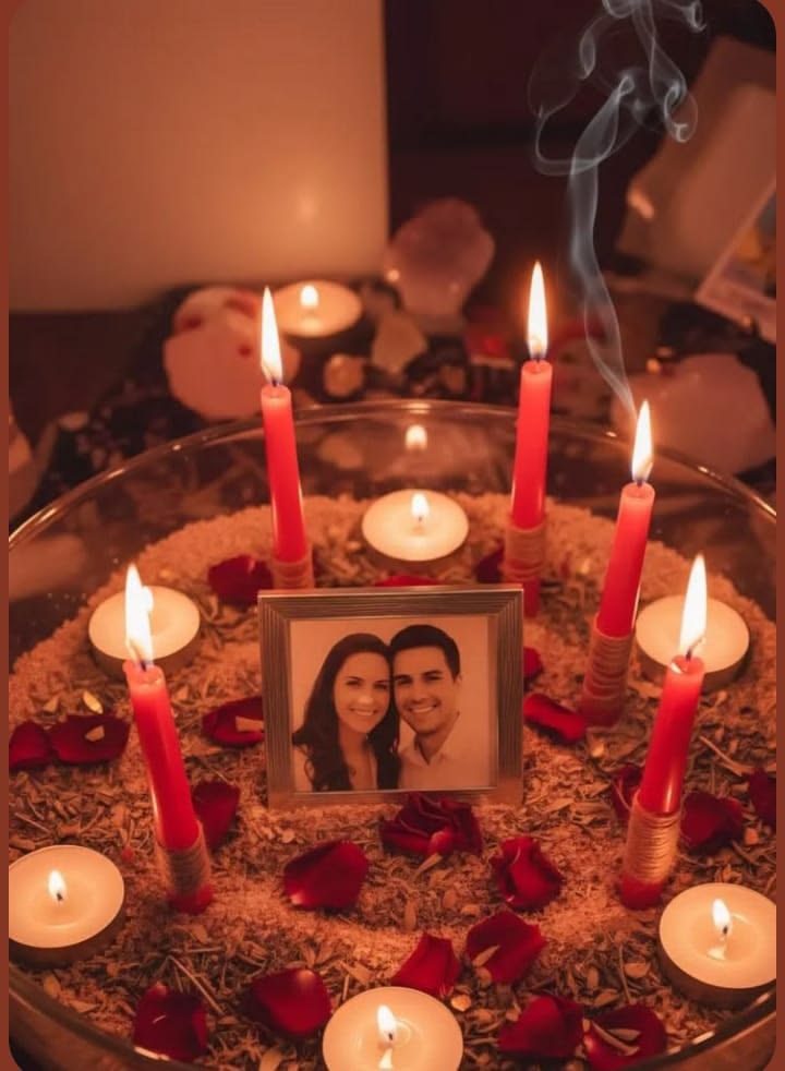 A couple's photo surrounded by red candles, rose petals and herbs