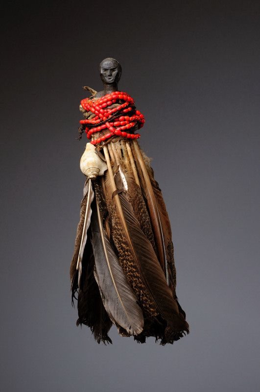 A charm made of feathers, shells and red beads